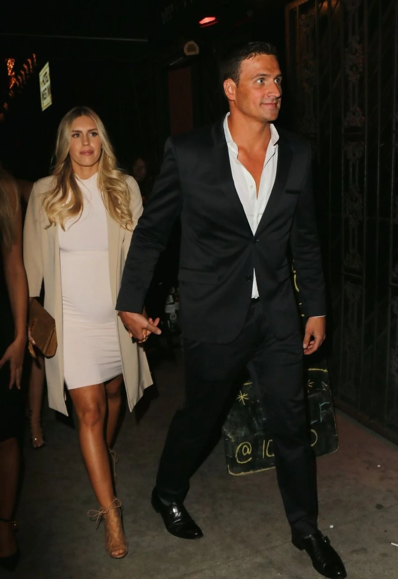 Kayla Rae Reid u bijeloj haljini i Ryan Lochte u odijelu drže se za ruke.