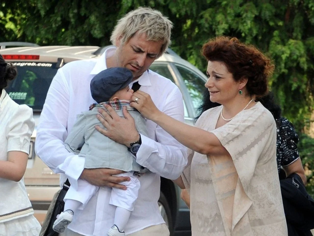 Vlado Šola drži dijete u naručju dok supruga Nataša promatra
