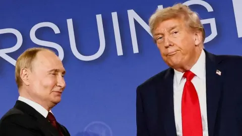 Donald Trump i Vladimir Putin stoje jedan pored drugoga ispred plave pozadine.