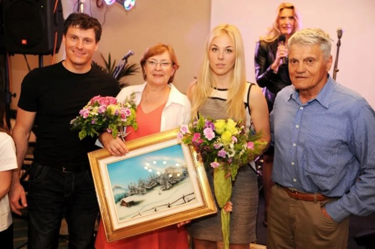 Obitelj Kostelić s cvijećem i uokvirenom slikom