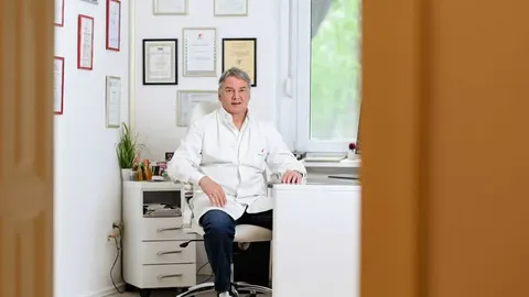 Ginekolog Gordan Crvenković sjedi u ordinaciji u bijeloj kuti