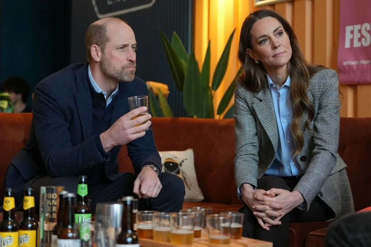 Princ William i Kate Middleton sjede na kauču i razgovaraju.