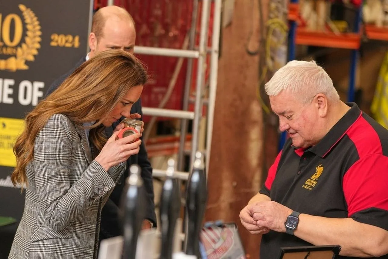 Kate Middleton miriše sastojke u staklenci dok obrtnik objašnjava proces.