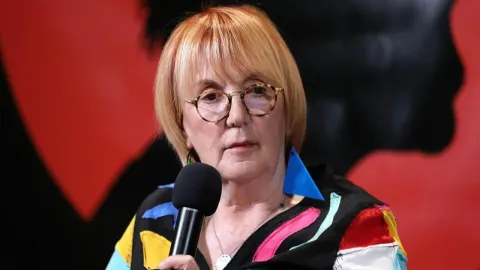 Portret Vedrane Rudan s mikrofonom u ruci na javnom događaju.