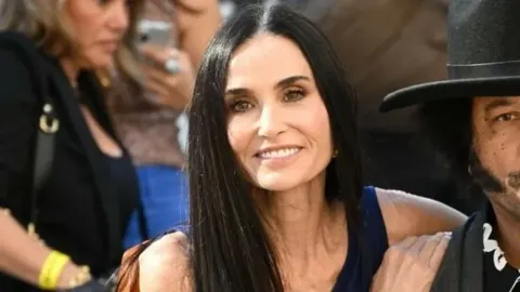 Demi Moore s dugom crnom kosom smiješi se na premijeri filma.