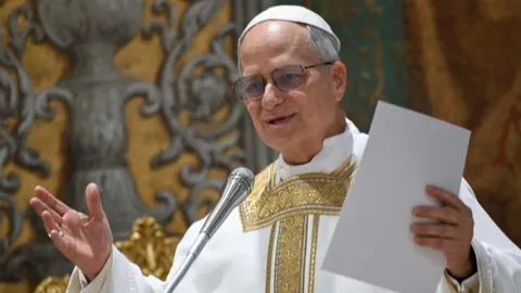 Papa Lav XIV drži govor ispred mikrofona u bijeloj halji sa zlatnim detaljima.