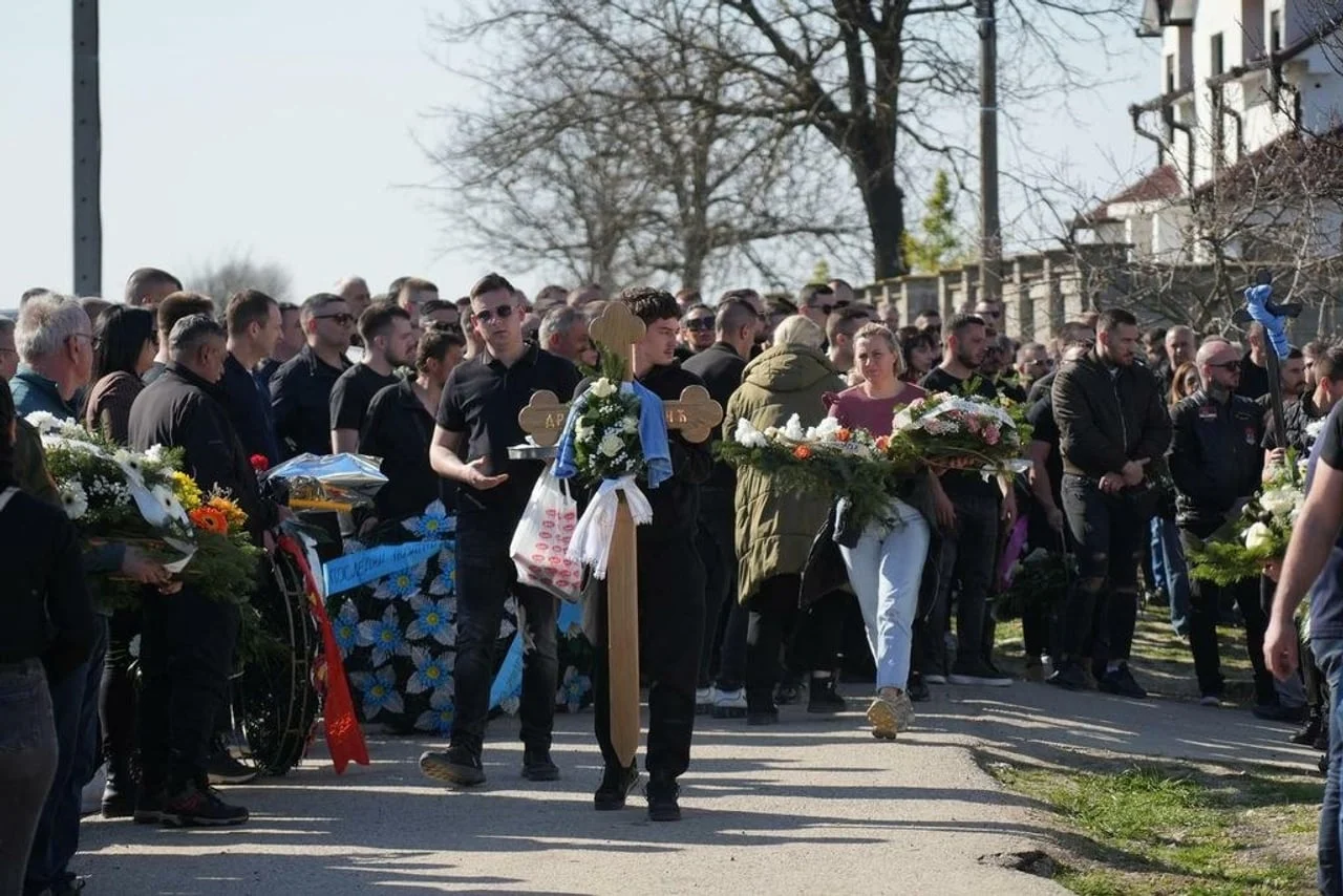 Povorka ljudi s cvijećem i velikim drvenim križem na putu