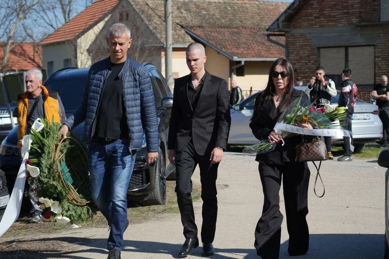 Skupina ljudi u crnini nosi vijence na sprovodu u Brestaču