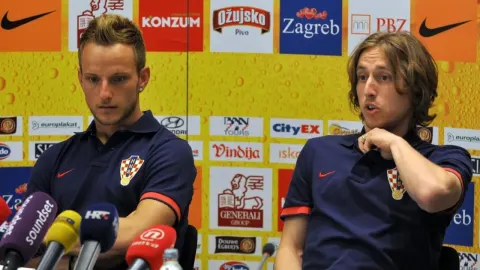 Ivan Rakitić i Luka Modrić sjede za stolom na konferenciji za medije u dresovima.