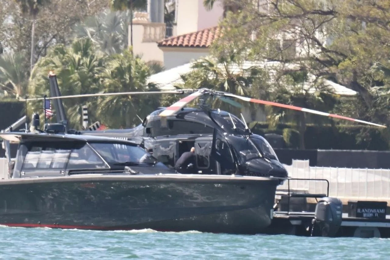 Crni helikopter parkiran na platformi uz luksuzno plovilo