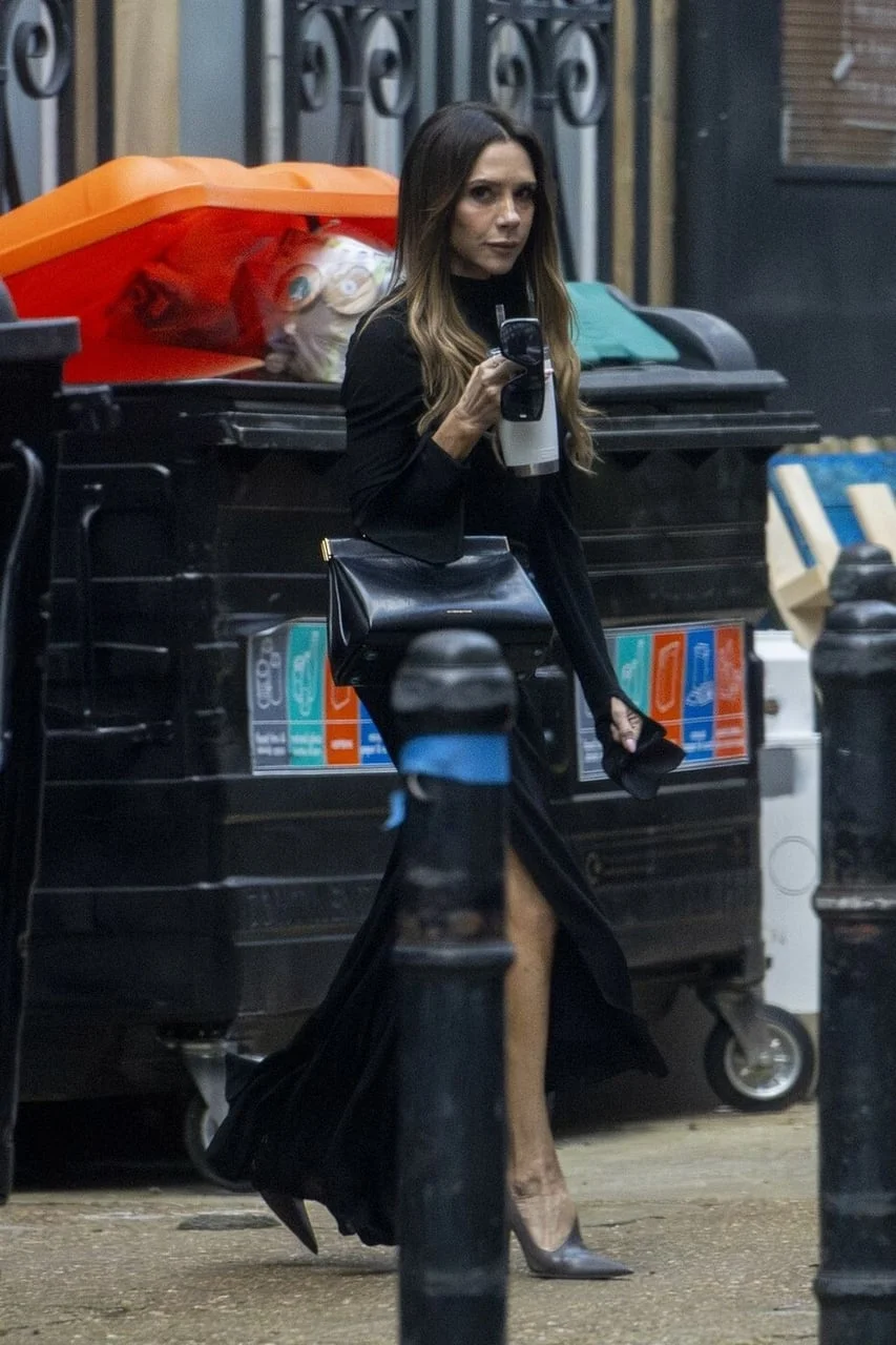 Victoria Beckham hoda ulicom u dugoj crnoj haljini s prorezom