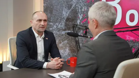 Ministar Ivan Anušić u tamnom odijelu sjedi u studiju tijekom intervjua.