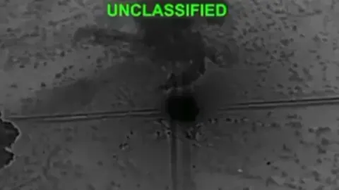 Crno-bijela snimka iz zraka s oznakom UNCLASSIFIED prikazuje metu na terenu.