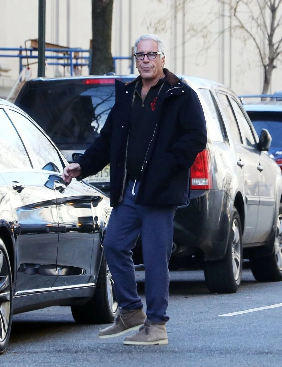 Jeffrey Epstein u plavoj jakni i trenirci stoji pored automobila