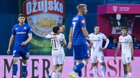 Nogometaši Slaven Belupa slave pogodak dok igrači Dinama razočarano stoje na terenu.