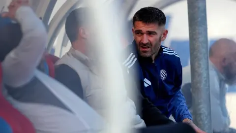 Marko Livaja sjedi na klupi za pričuve u sportskoj opremi HNK Hajduk.