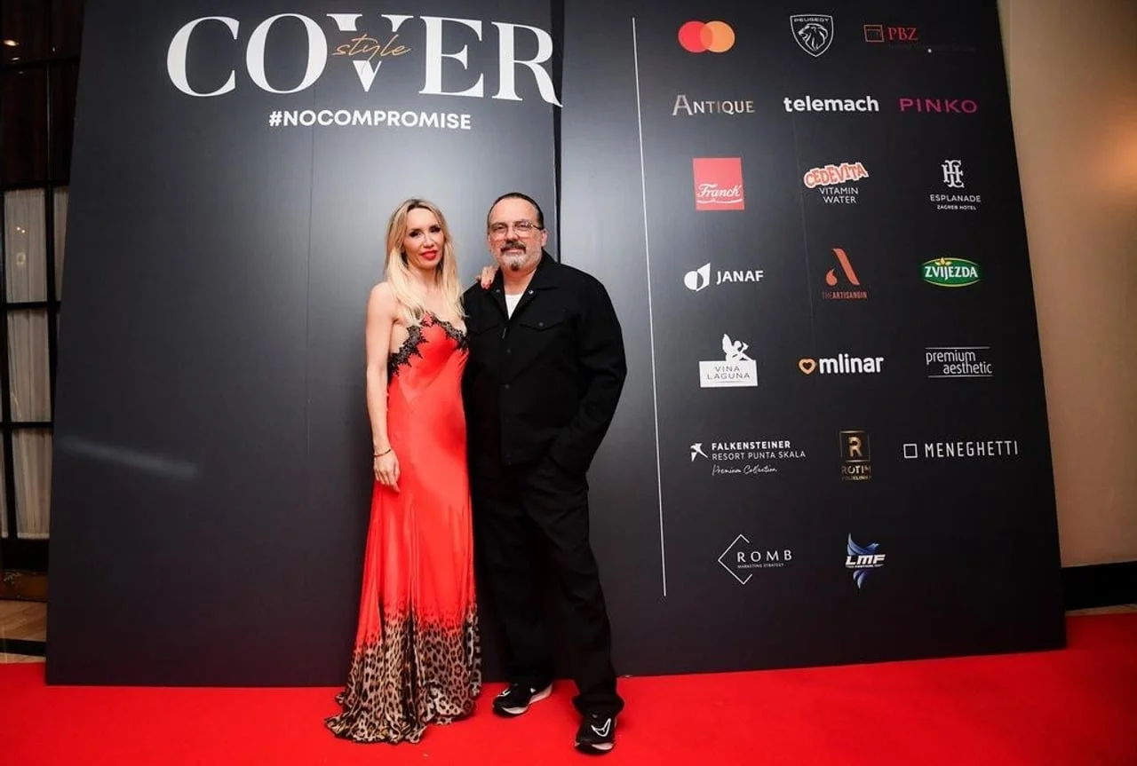 Tony i Dubravka Cetinski na crvenom tepihu ispred zida s logotipima.