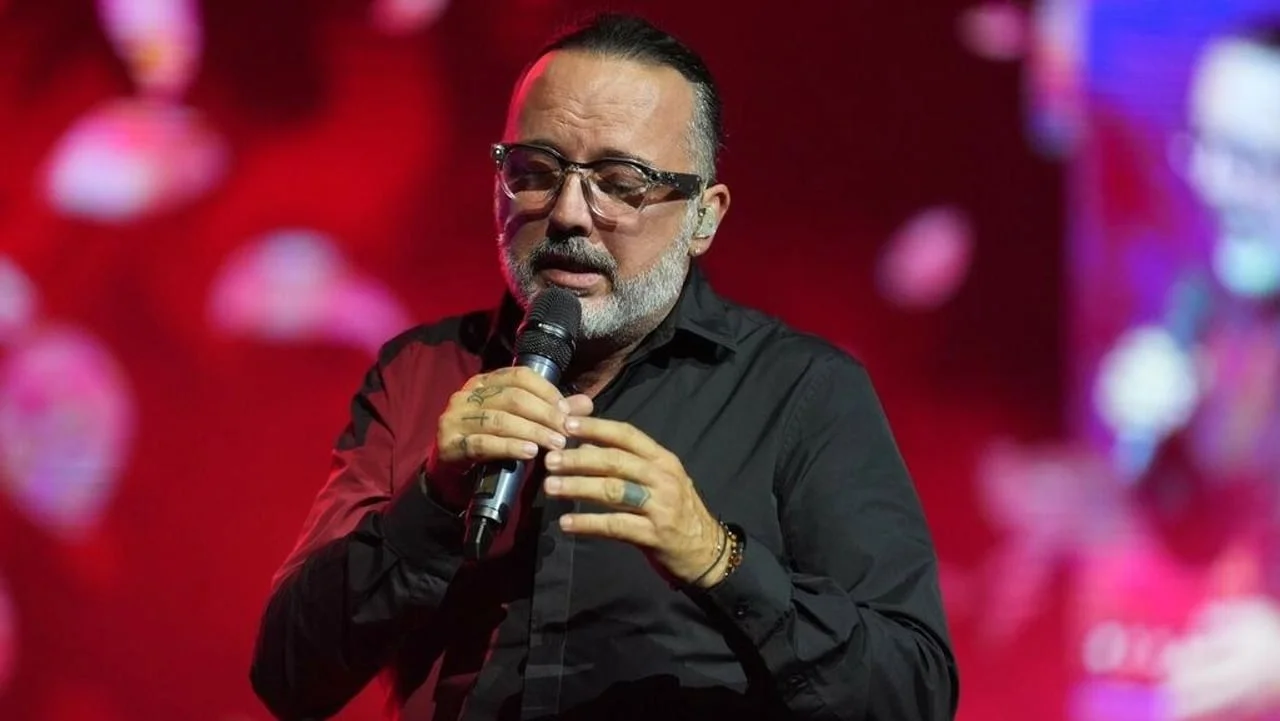 Krupni plan Tonyja Cetinskog dok pjeva emotivnu pjesmu na pozornici.