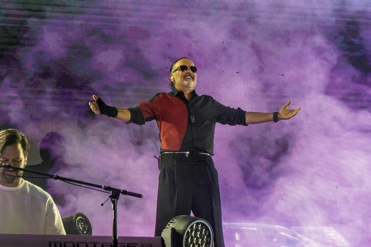 Tony Cetinski širi ruke na pozornici ispred ljubičastog zaslona.