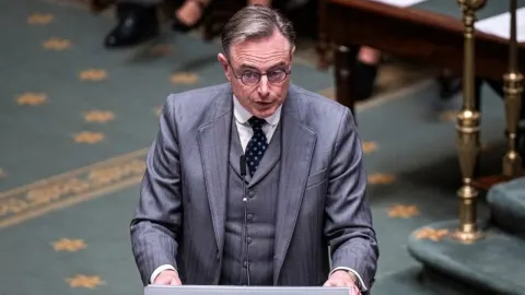 Bart De Wever u sivom odijelu govori za govornicom u parlamentu