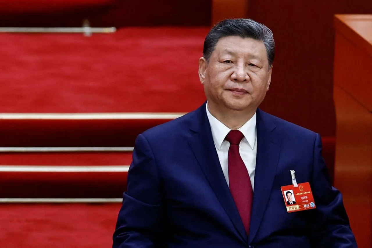 Kineski predsjednik Xi Jinping u tamnom odijelu ispred crvene pozadine