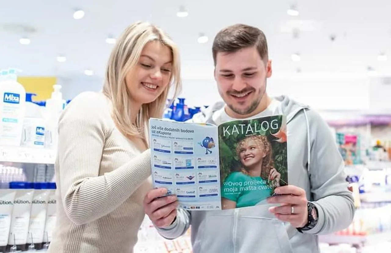 Muškarac i žena listaju prodajni katalog u trgovini kozmetike i kemikalija.