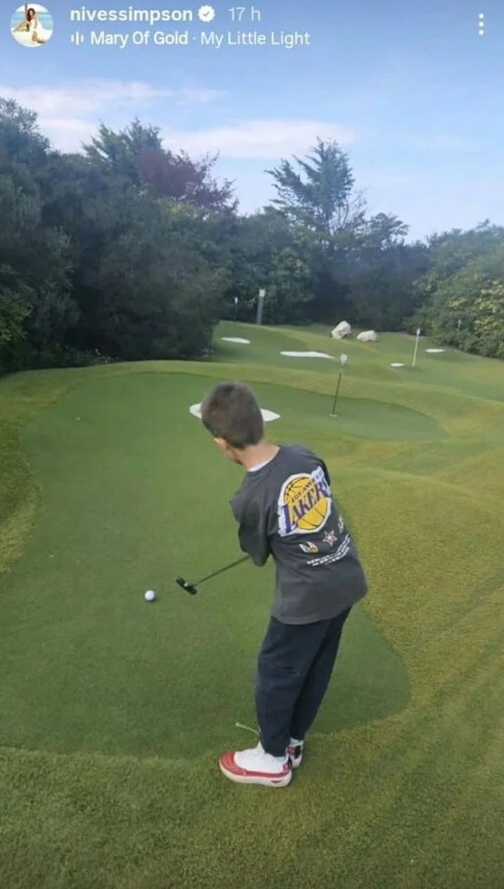 Dječak s leđa udara golf lopticu na zelenom terenu